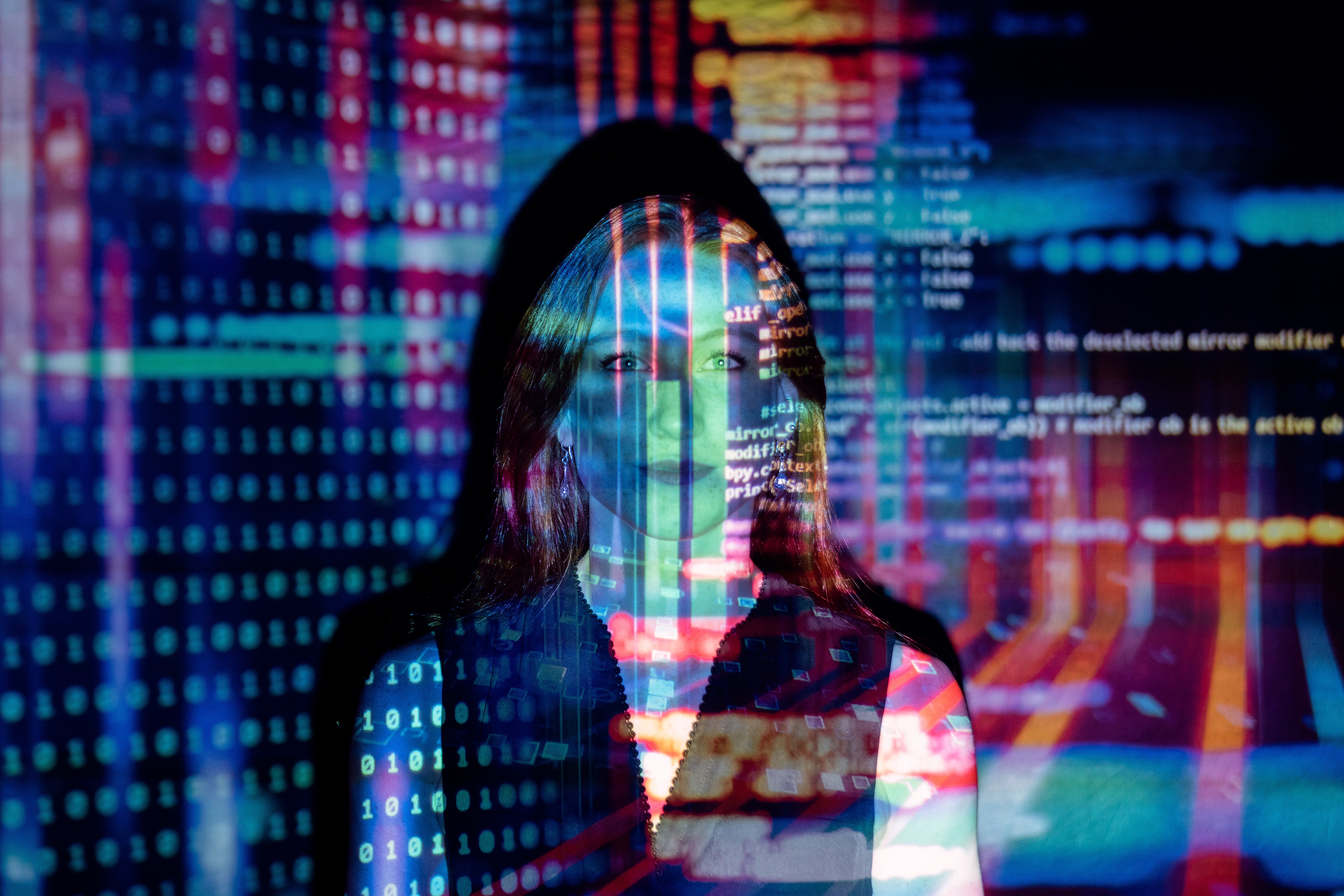 female engineer surrounded by lights and lines of computer code